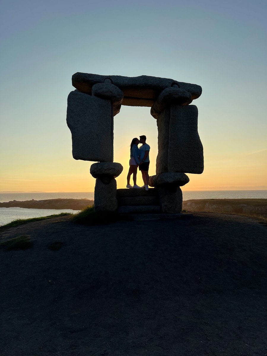 La pareja besándose al atardecer dentro de un mirador con forma de ventana